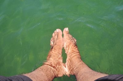 Low section of man relaxing in lake