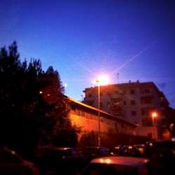 Cars on illuminated street in city at night