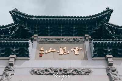 Low angle view of text on building roof