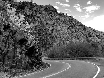 Road leading towards mountains against sky