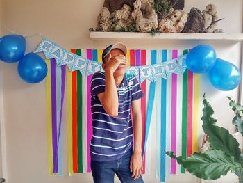 Man standing against balloons and text