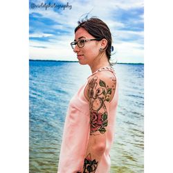 Midsection of young woman at beach against sky