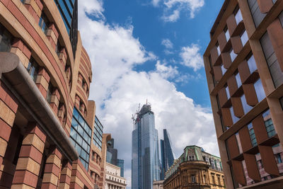 Low angle view of buildings against cloudy sky