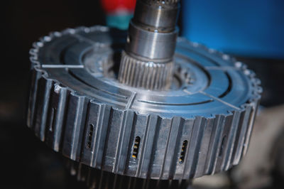 A close-up of a pack of clutches on a shaft with a gear from an automatic transfer case of a four