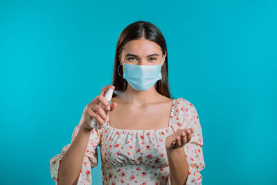 Portrait of beautiful young woman against blue background