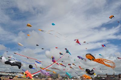 Low angle view of kites flying against sky