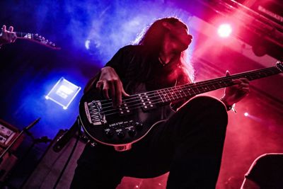 Low angle view of man playing guitar at music concert