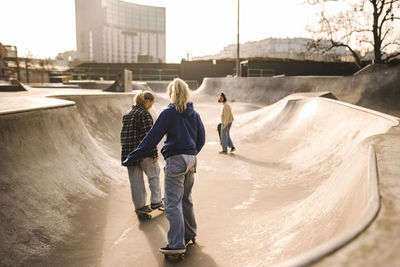 Teenage girls skateboarding in skatepark