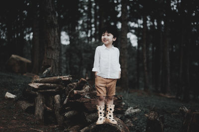 Portrait of smiling young woman standing in forest