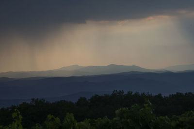 Scenic view of silhouette mountains against sky at sunset