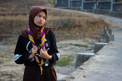 Portrait of beautiful young woman standing outdoors