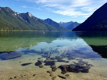 Scenic view of lake by mountains against sky