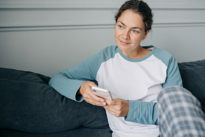 Portrait of young man sitting on sofa at home