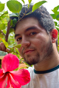 Portrait of young man with red flower