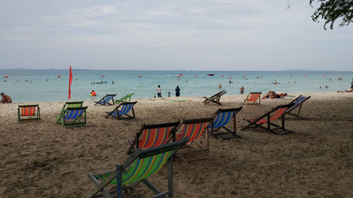 Chairs on beach against sky