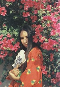 Young woman standing by flowering plants