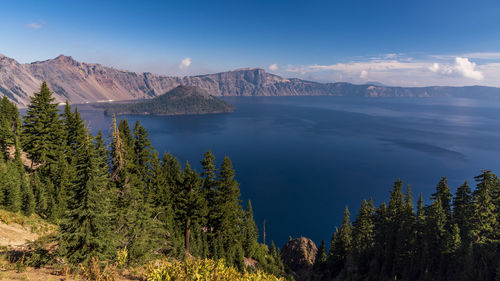 Scenic view of sea and mountains against sky