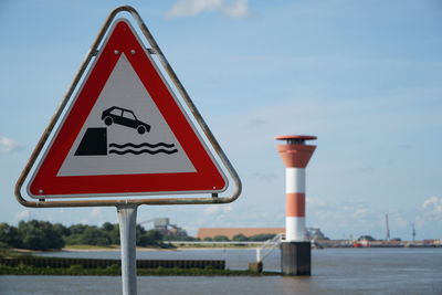 Close-up of road sign against sky