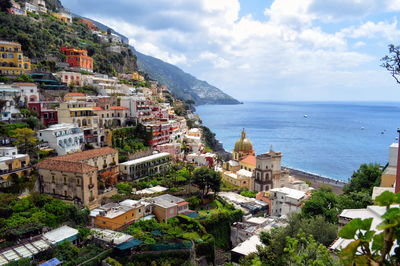 High angle view of townscape by sea against sky