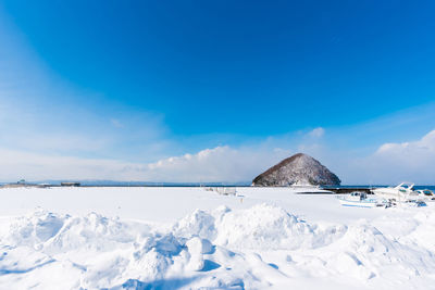 Scenic view of snowcapped mountains against blue sky