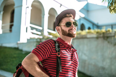 Portrait of young man wearing sunglasses standing outdoors