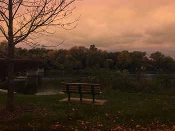 Empty chairs and table against trees at sunset