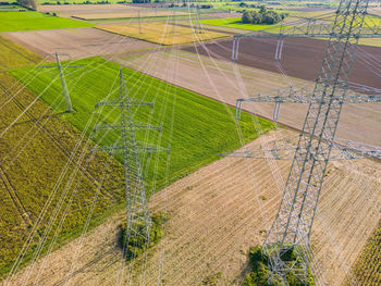 Aerial view of electricity pylons and power lines in the field