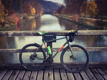 Bicycle on bridge over river during autumn