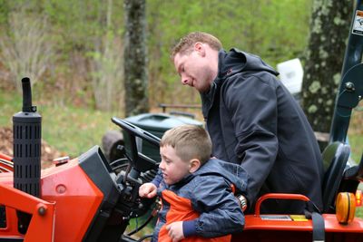 Father and son on car against trees