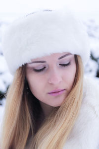 Close-up portrait of a young woman in snow