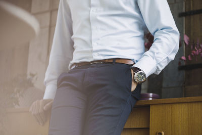 Midsection of businessman with hand in pocket leaning on sideboard in portable office truck