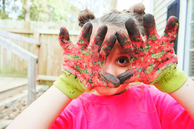 Portrait of cute girl showing dirty hands outdoors