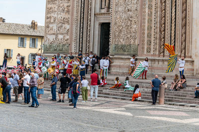 People standing on street against building in city