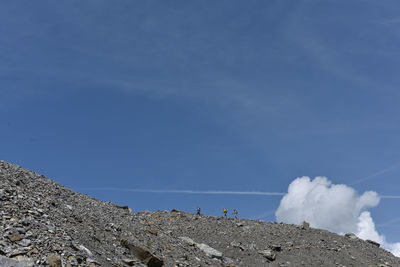 Panoramic shot of rocks by sea against blue sky