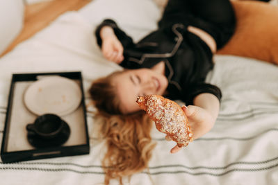 High angle view of woman with stuffed toy on bed at home