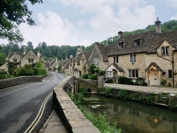 View of buildings against cloudy sky in castle combe, wiltshire