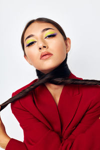 Portrait of young woman against white background