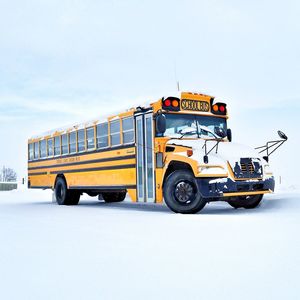 School bus on road against sky during winter