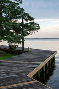 Pier by swimming pool by sea against sky