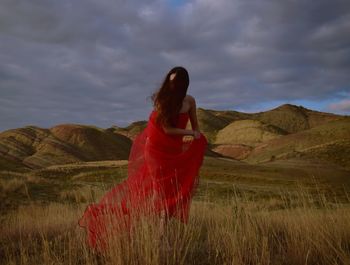 Woman standing on field against sky