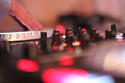 Cropped hand of dj playing turntable in nightclub