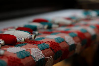 Close-up of multi colored thread spools on textile