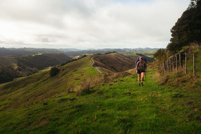 Full length of man walking on landscape against sky