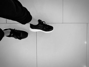 Low section of person sitting on tiled floor