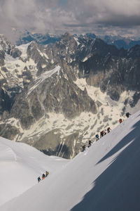 High angle view of people climbing snowcapped mountain