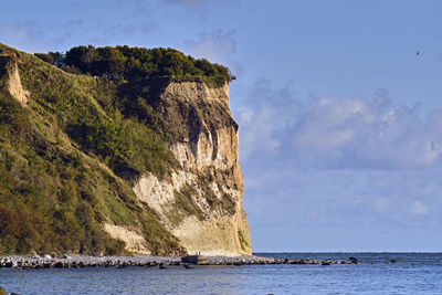 Rock formations by sea against sky