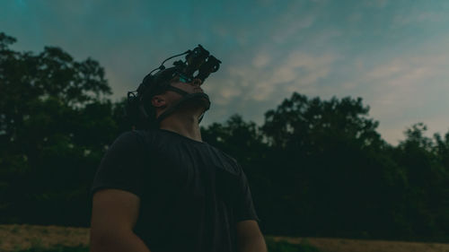 Man looking at camera against sky during sunset
