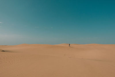 Scenic view of desert against blue sky