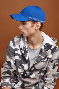 Young man looking away against gray background