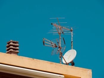 Low angle view of communications tower against blue sky